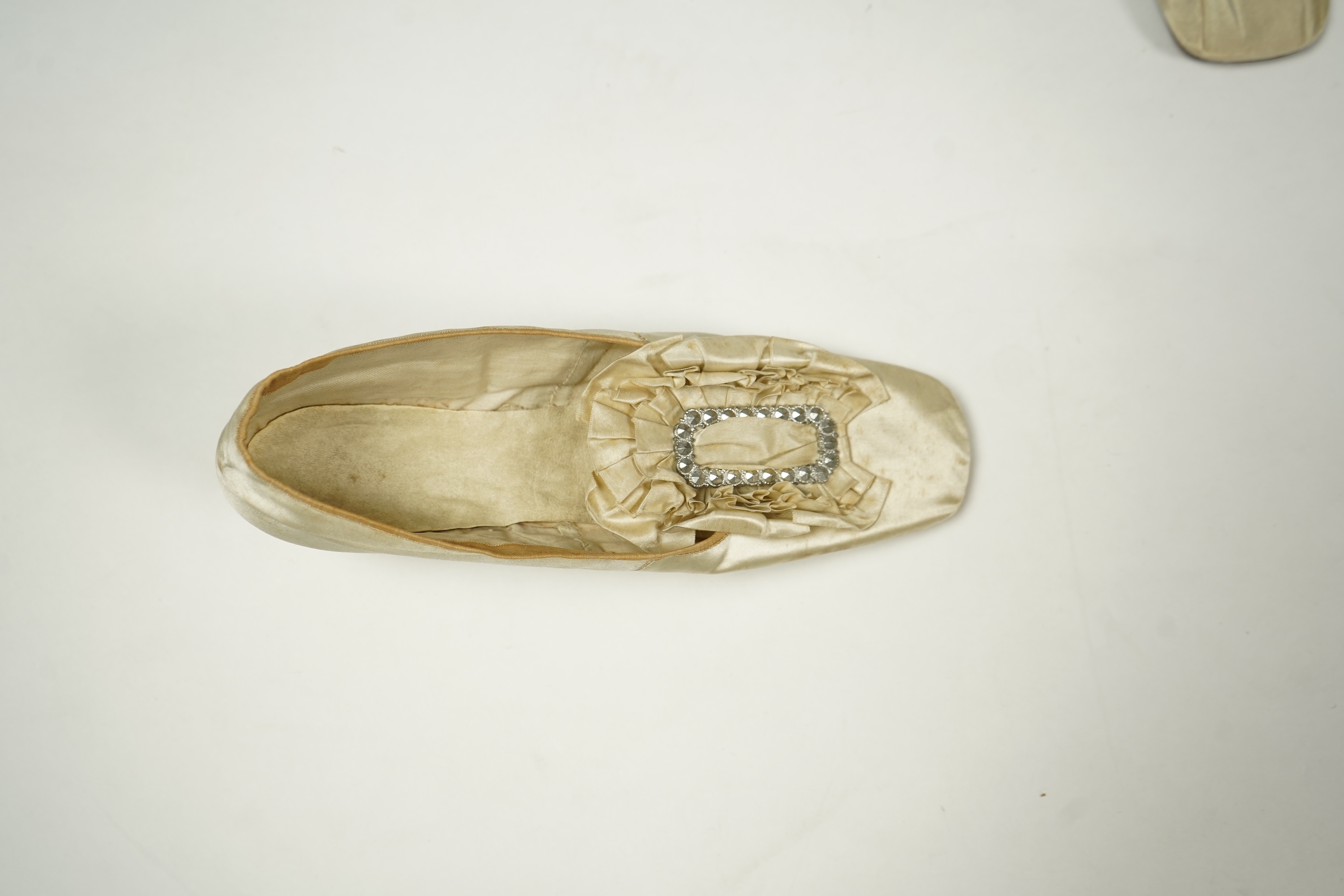 A 19th century hand made cream kid leather ladies ankle boot and four differing cream silk and satin single wedding shoes. All with leather soles. Possibly a traveller's sample range. Boots 24.5cm long (heel to toe). Con